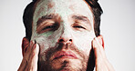 Facial, skincare and clay mask with portrait of man in studio for beauty, spa treatment and dermatology. Cosmetics, self care and pore cleaning benefits with person on white background for glow