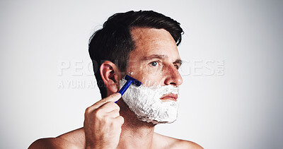Buy stock photo Shaving, foam and man with beard in studio for wellness, grooming and haircare on white background. Razor, space and person with tools for facial hair, epilation and shave for morning routine