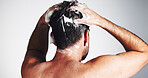 Shampoo, hair care and beauty with man in studio for shower, scalp health and dandruff treatment. Growth, texture and grooming with person on white background for cosmetics, shine and cleaning