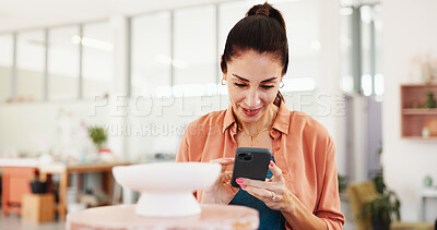 Buy stock photo Pottery, small business and woman in studio, smartphone and social media for startup. Mature person, entrepreneur and artist in workspace, creative and product design with cellphone, app and internet