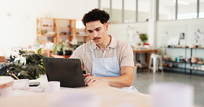 Buy stock photo Pottery, creative and man in studio on laptop for inventory, logistics and art checklist of ceramic designs. Business, workshop and person on computer for planning, online order and store website