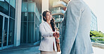 Business people, meeting and city with handshake for partnership, b2b or corporate deal. Employees, colleagues or shaking hands with smile for greeting, introduction or agreement in an urban town