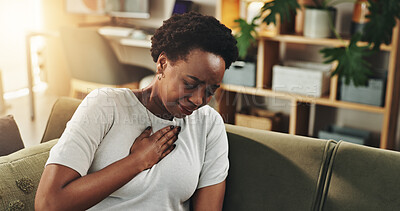 Buy stock photo Breathing, chest pain or heartburn with black woman on sofa in living room of home for discomfort. Asthma, emergency or lungs with person in apartment for symptoms of cardiac arrest or tuberculosis