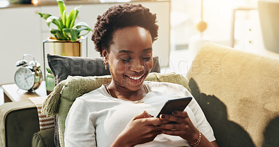 Buy stock photo Black woman, happy and typing with phone in home for text message, dating site and social media scroll. Relax, person and internet connection on sofa for streaming service, reading ebook and research