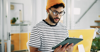 Creative, man and reading on tablet in office for research, schedule update and review newsletter. Male journalist, digital and editing article, story information and feedback of magazine publication