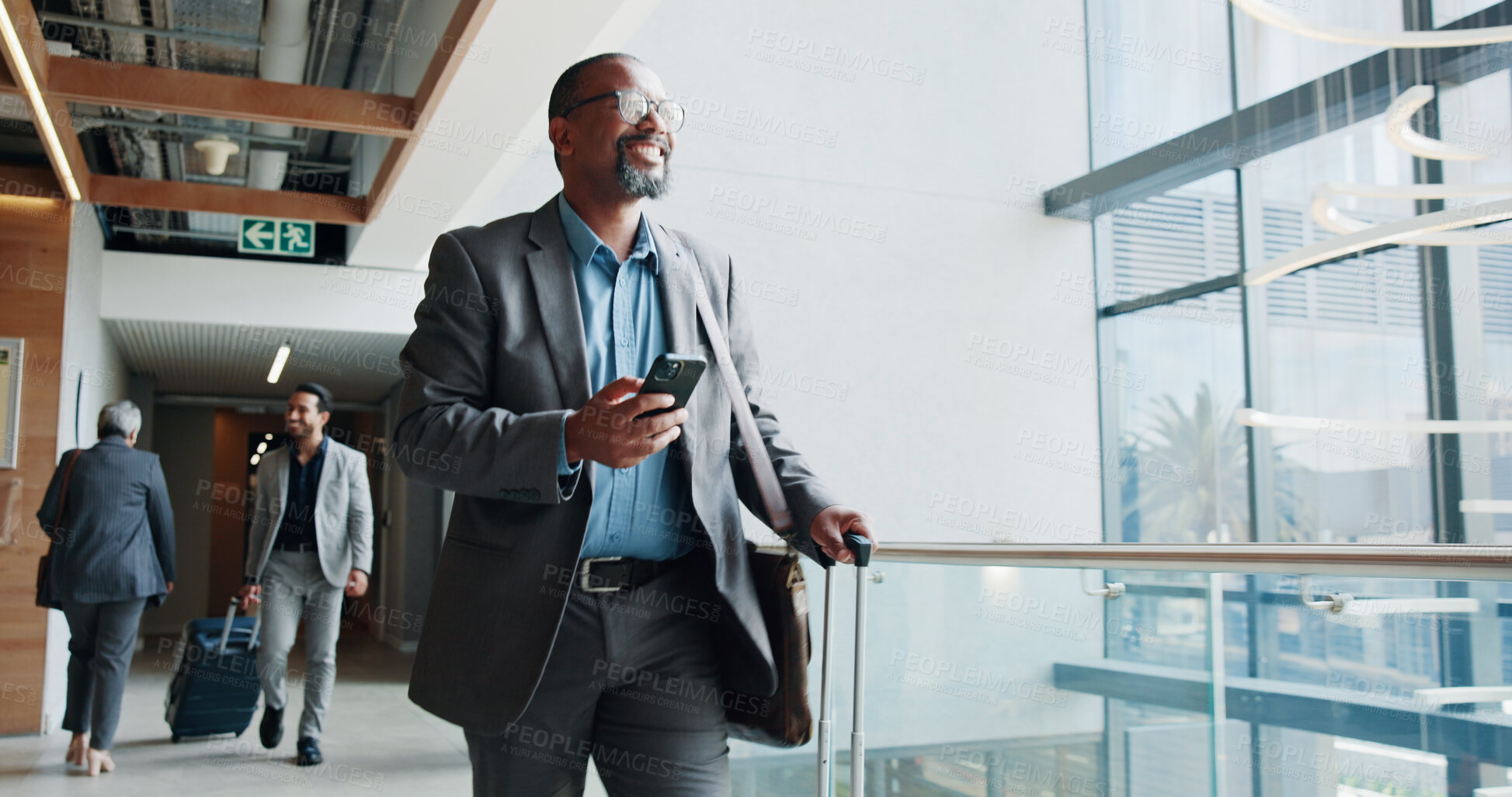 Buy stock photo Happy, businessman and walking with phone or suitcase for travel, job opportunity or career trip at airport. Man, employee or traveler with smile, mobile smartphone or luggage for commute or flight