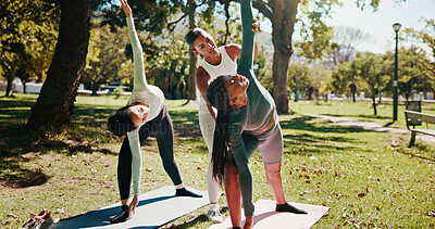 Buy stock photo Outdoor, instructor and women with stretching for yoga, wellness and chakra with support for balance. Nature, people and coach with helping for flexibility, triangle pose and fitness for yogi group