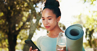 Buy stock photo Woman, smartphone and exercise mat in park for yoga, water bottle and check social media after session. Person, fitness app or blog with reading text, health update and drink with equipment outdoor
