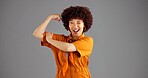 Portrait, flexing arms and woman with wink, win or power with confident personality on grey studio background. Smile, happy person or victory with gesture, space or female empowerment with challenge