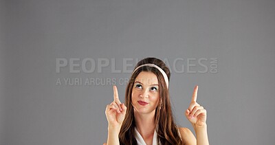 Buy stock photo Smile, woman and pointing up to space for marketing, mockup or discount deal. Happy person, advertising and presentation in studio for sales, promotion or special offer coming soon on gray background