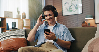 Buy stock photo Happy man, sofa and headphones with music for audio streaming, podcast or entertainment at home. Male person, relax or user with smile on mobile smartphone for sound, playlist or songs at house