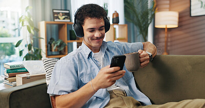 Buy stock photo Headphones, man and smile with phone on sofa for streaming service, watching online video and coffee break. Relax, person and smartphone in home for audio playlist, music album or internet connection