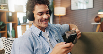 Buy stock photo Headphones, man and relax with phone on sofa for streaming service, watching online video and coffee break. Happy, person and smartphone in home for audio playlist, music album or internet connection
