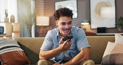 Buy stock photo Speaker phone, smile and man in home for communication, story and recording audio message for news. Voice note, mobile and person on sofa for call with contact, talking and question for ai assistant