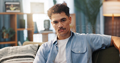Buy stock photo Man, sofa and serious in portrait in home, relax on day off or weekend break with confidence in living room. Calm, rest and comfortable on couch, male person with attitude and chill in house