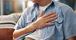 Hand, chest pain and man in home for health, panic attack or pressure for cardiovascular medical issue on sofa. Indigestion, heartburn or male person with respiratory illness for emergency at house