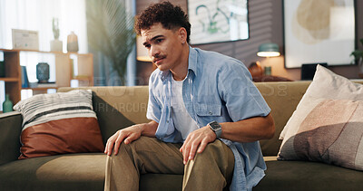 Buy stock photo Sad, home and man on sofa, thinking and thoughtful with depression in living room. Apartment, anxiety and person on couch, tired and contemplation with regret, mental health and memory with stress