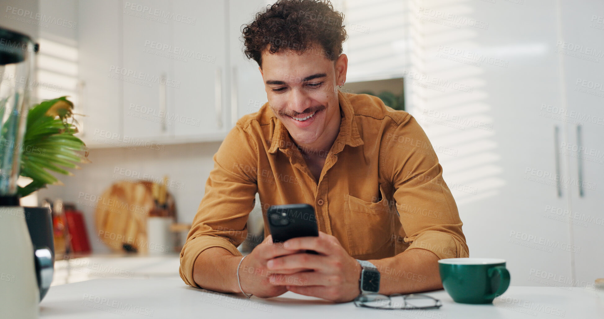 Buy stock photo Reading, smile and man on smartphone in kitchen for communication, morning news and message. Home, online and happy person on mobile for texting, social media and website to download application