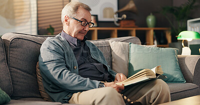 Buy stock photo Senior man, reading book and relax on couch with study, literature and fiction in lounge at apartment. Elderly person, novel and knowledge on sofa with language, info or storytelling in living room