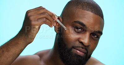 Buy stock photo Portrait, serum and black man in studio, skincare and dermatology on blue background. African person, facial cosmetics or model with dropper, hyaluronic acid and oil with collagen, glow or anti aging