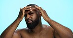Worry, face check and skincare for man, portrait and acne treatment in morning, serious and dermatology. Blue background, self care and black person with routine for beauty, inspection and studio