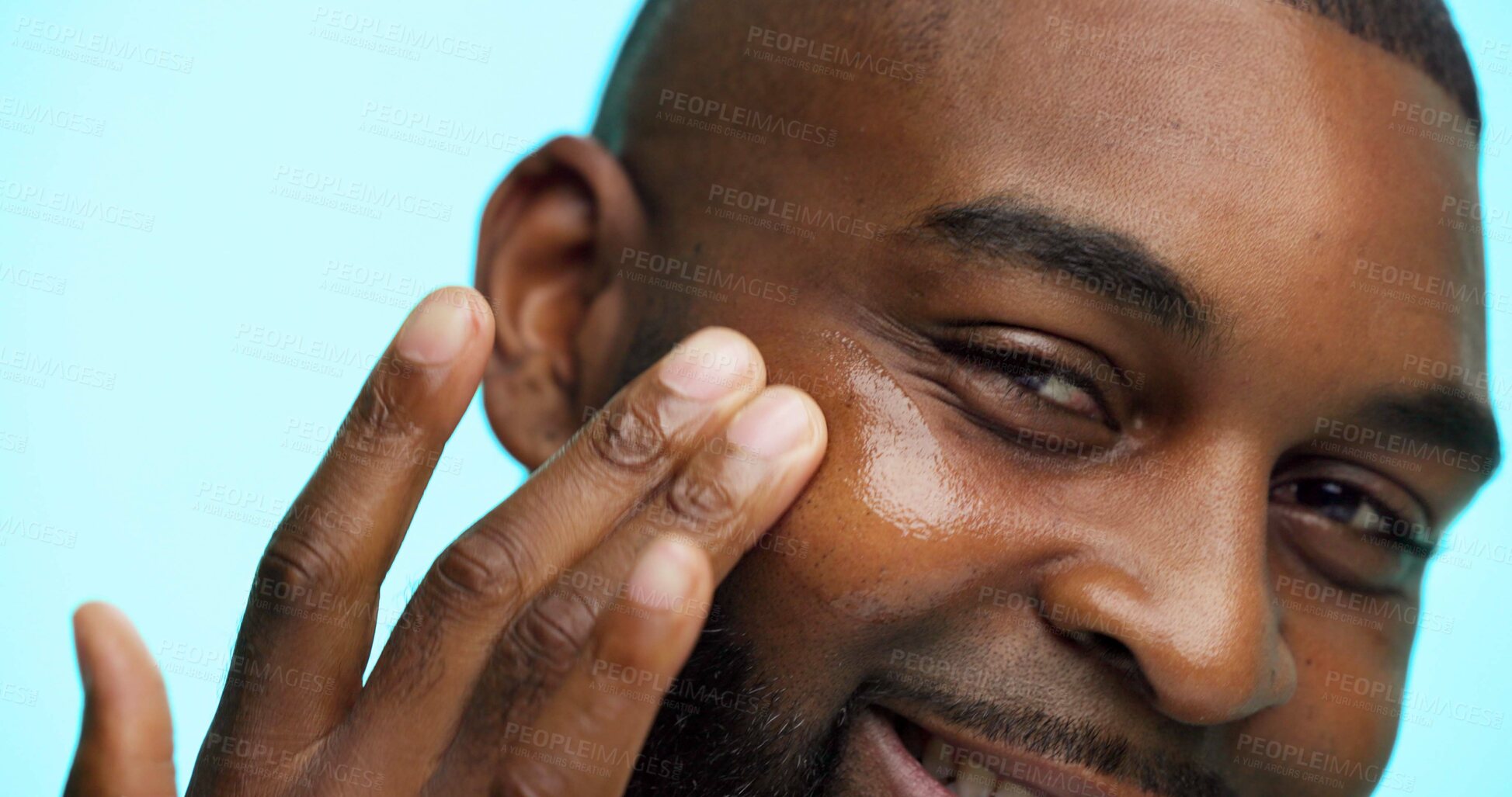 Buy stock photo Portrait, man and skincare for beauty in studio, healthy skin or moisturizer on blue background. Face, treatment and grooming with African person applying cosmetics, dermatology and hydration facial