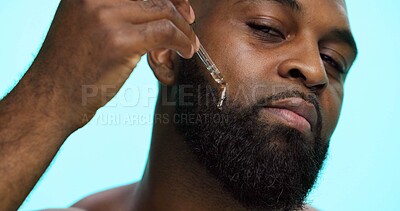 Buy stock photo Portrait, serum and black man in studio, beauty and dermatology on blue background. African person, facial cosmetics or model with dropper, hyaluronic acid and essential oil with shine or skincare