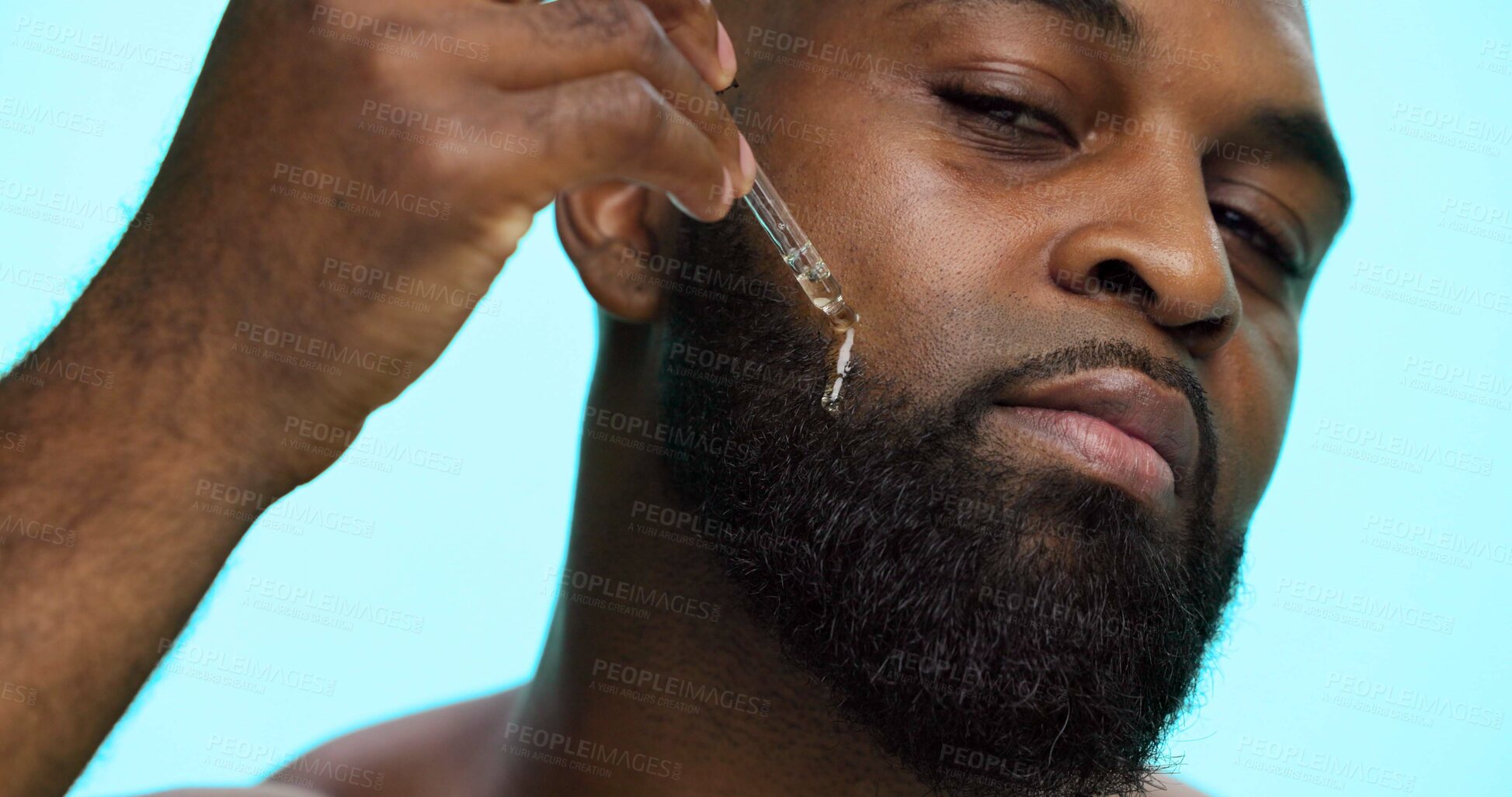 Buy stock photo Portrait, serum and black man in studio, beauty and dermatology on blue background. African person, facial cosmetics or model with dropper, hyaluronic acid and essential oil with shine or skincare