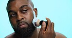 Brush, foam and shaving with black man in studio, cosmetic care and product with skincare on blue background. Soap, cream or facial maintenance for hair removal, beauty or grooming for hygiene