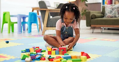 Buy stock photo Kid, block and building with toys at office for fun activity, assessment or playing on floor. Black girl, child or student with shapes for playful learning, fine motor skills or elementary education