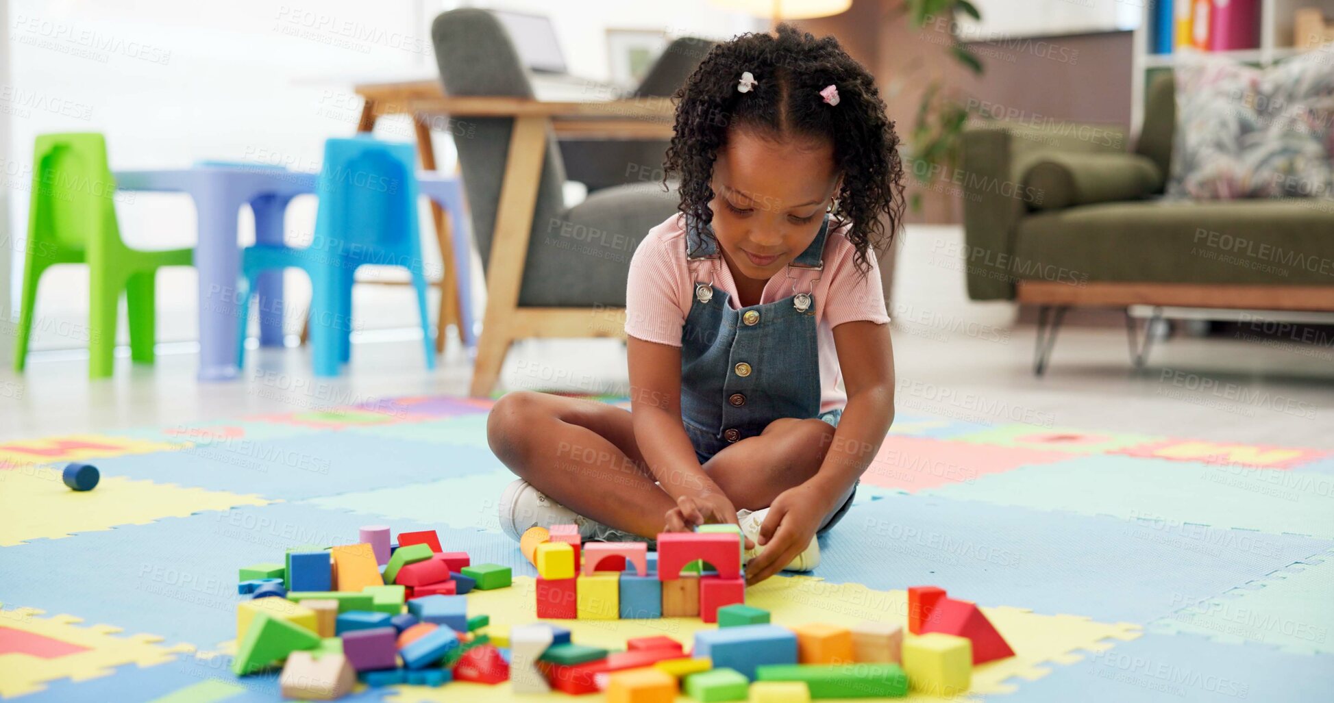 Buy stock photo Kid, block and building with toys at office for fun activity, assessment or playing on floor. Black girl, child or student with shapes for playful learning, fine motor skills or elementary education