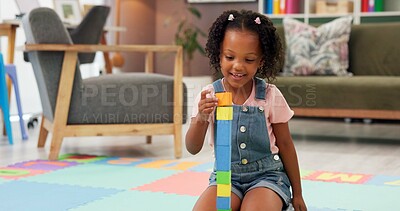 Buy stock photo Black girl, block and building with toys for fun activity or playing on floor at therapy office. Kindergarten kid, child or student with shapes for playful learning, fine motor skills or education
