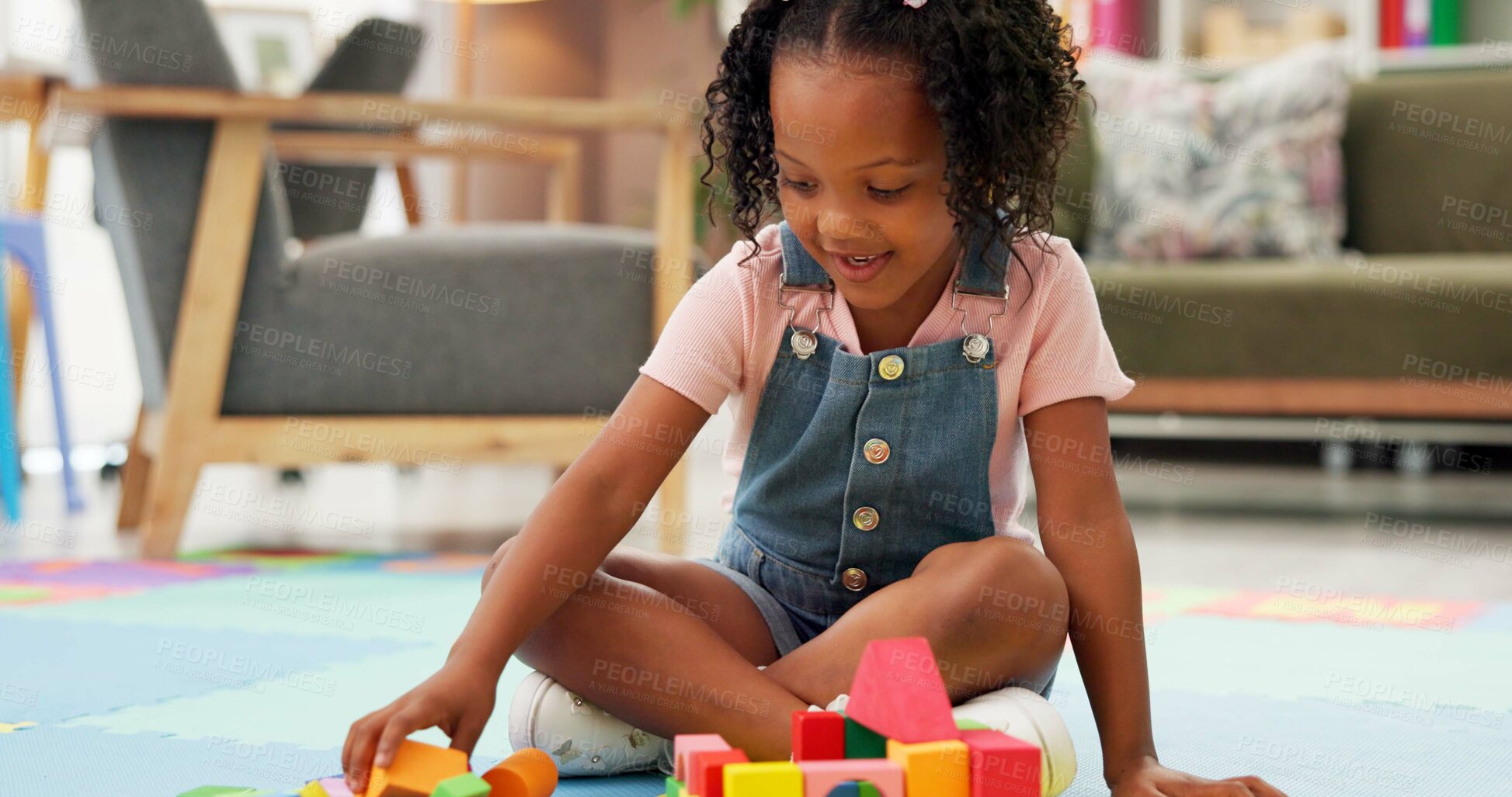 Buy stock photo Black girl, block and building with toys for playing or fun activity on floor at therapy office. Kid, child or student with shapes or assessment for playful learning, fine motor skills or education