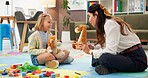 Therapy, woman and girl with toys, talk and listen with guide for emotional assessment on floor. Person, psychologist and child with dolls, playful and consulting for test at mental health clinic