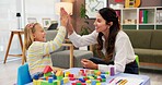 Therapist, child and building blocks for high five, celebration and progress in office. Psychologist woman, pediatrics and girl for toys, clinic or consultation for patient support or development