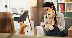 Teddy bear, psychology and therapist with child in office for help with emotions, mental health or evaluation. Talk, appointment and female psychiatrist with fluffy toy for kid counseling at clinic.