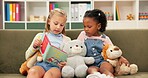 Girls, reading or sofa with book for story time, education or learning together at elementary school. Children, kids or students with novel on couch for childhood development, fiction or imagination