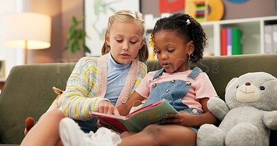 Buy stock photo Girls, reading or sofa with book for education, learning or story time together at elementary school. Children, kids or students with novel on couch for childhood development, fiction or imagination