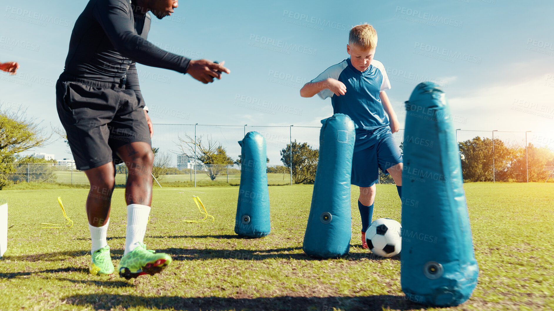Buy stock photo Coach, playing and child with ball, sports field and performance with energy in morning, cardio or kick. Training, football and kid with sportswear for game, growth or development of boy with fitness