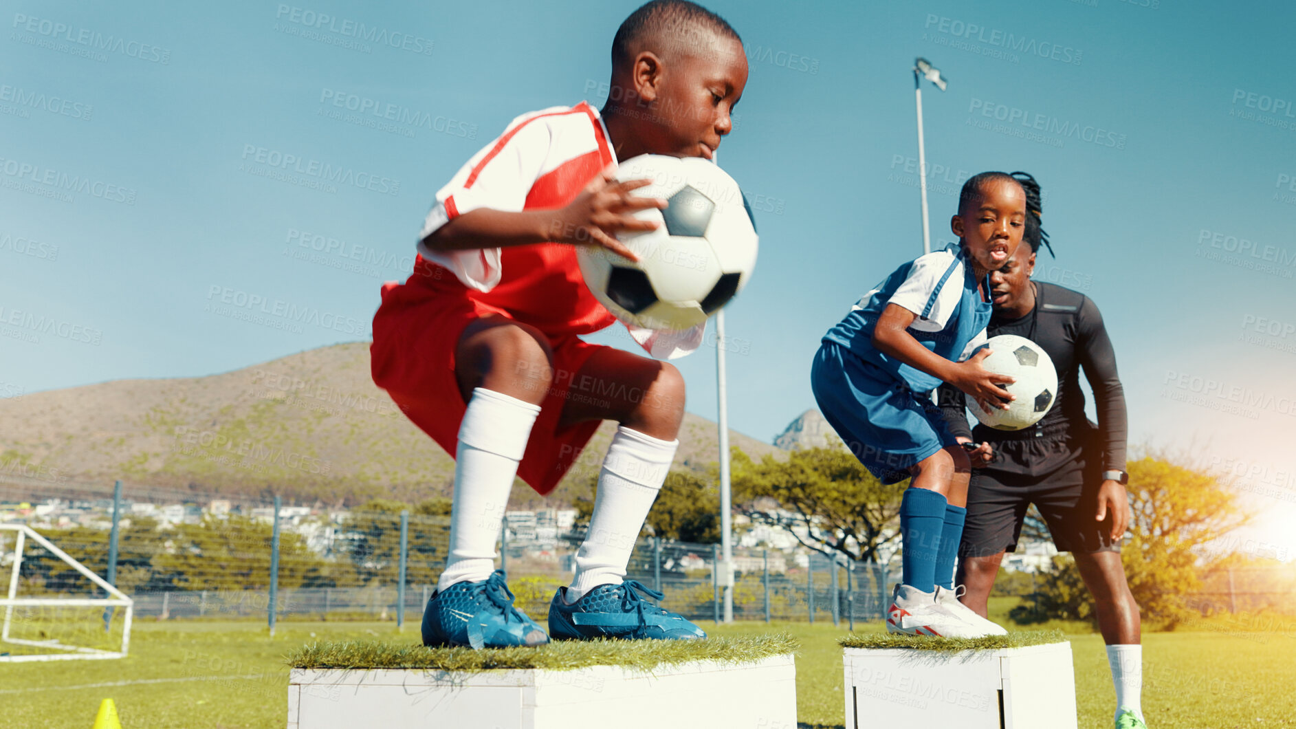 Buy stock photo Black kids, jumping and ball for soccer practice of fitness training, balance exercise and sports drill. Boys, box and equipment for playing game, learning skills and team challenge of match activity