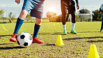 Sports field, legs and children with ball, kick and athlete with coach for practice in morning or cardio. Playing, football and kids with sportswear for game, growth and development with fitness