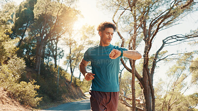 Buy stock photo Fitness, running and watch with man outdoor on road in forest for cardio, challenge or performance. Exercise, time and tracking with athlete or runner in nature for sports, training or workout
