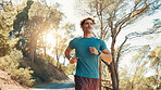 Man, fitness and running with trees in nature for workout, exercise or cardio training on mountain. Active, male person or runner jogging with path or road for race, sprint or health and wellness