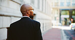 City, commute and walking with business black man outdoor on sidewalk for travel to work location. Back, journey and thinking with employee in urban town for inspiration or opportunity as pedestrian