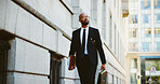 Businessman, lawyer and walking with briefcase in city for corporate travel, law or job opportunity. Man, employee or attorney with folder or bag for court case or legal advice in an urban town