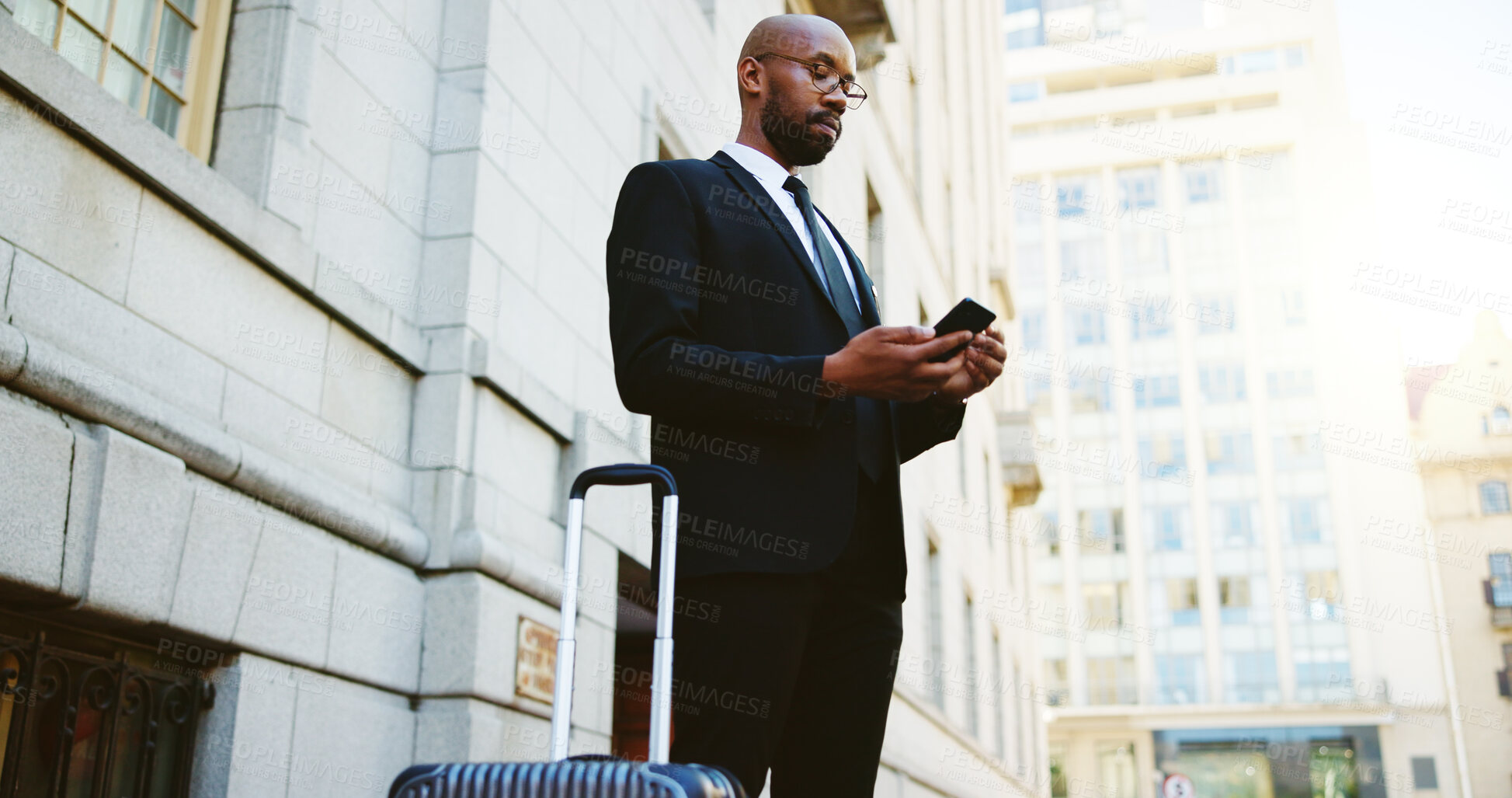 Buy stock photo Suitcase, travel and black man in city with phone for business communication, contact or email. Cellphone, corporate trip and African male financial manager booking a shuttle on app in urban town.