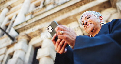 Buy stock photo Cellphone, lawyer and businesswoman in city with communication, contact or email with legal client. Phone, research and female attorney with online networking for legislation case in town from below.