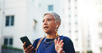 Buy stock photo Earphones, listening and phone call with business woman in city for communication, real estate listing and connection. Networking, client feedback and property viewing schedule with mature person 