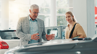 Buy stock photo People, customer and businessman with discussion for car dealership, transport model and rental service. Motor showroom, woman and mature seller with pitch for vehicle features, assistance or talking