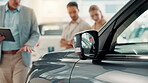 Salesman, customer and tablet by car at dealership with sale, negotiation and finance planning at shop. Couple, people and agent for test drive, purchase and guide for deal with vehicle at showroom